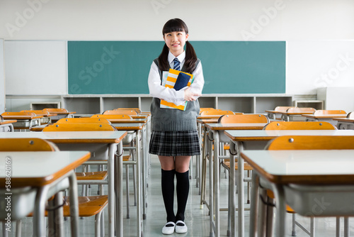 教室でノートを抱える女子中学生 photo