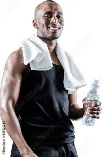 Portrait of happy muscular man with towel around neck holding bottle