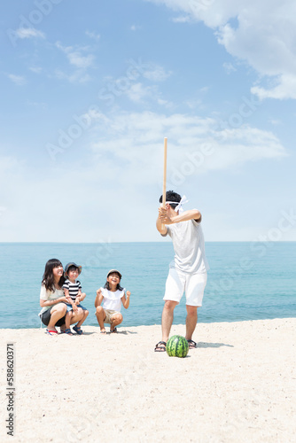 浜辺でスイカ割りをする家族 photo