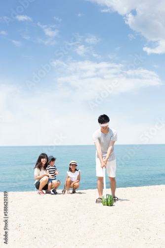 浜辺でスイカ割りをする家族 photo