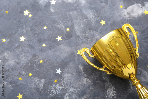 Gold cup with stars on dark background, closeup