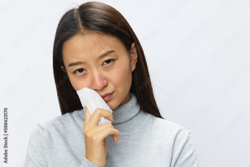 Sad Asian woman holding hand with handkerchief and coughing up flu and cold, stuffy nose viral disease asthma and allergies covid 19, white background Sad Asian woman holding hand with handkerchief and coughing up flu and cold, stuffy nose viral disease asthma and allergies covid 19, white background