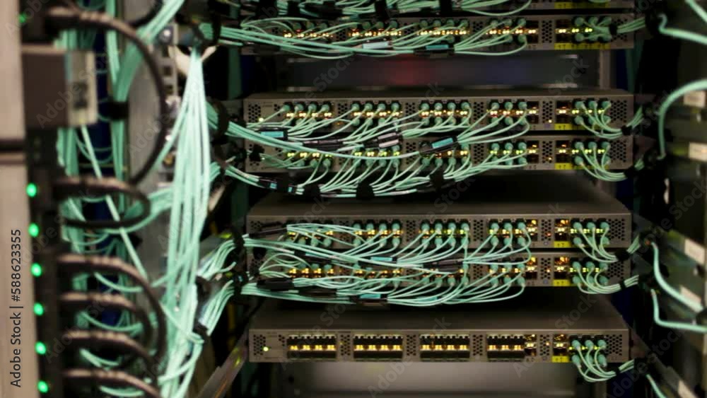 Green wires plugged in to servers and storage in a data center, server room