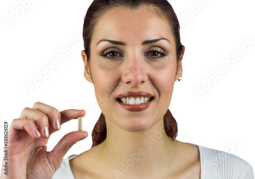 Close-up portrait of happy woman holding pill
