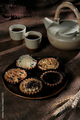 Pie on rustic plate with brown background. Tea pot n cup in back