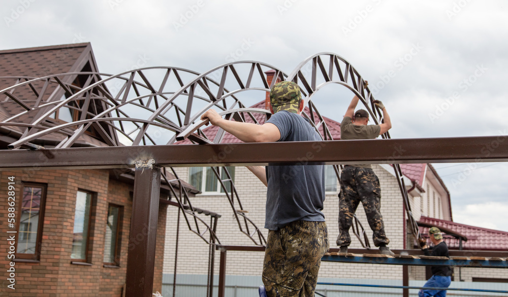 Naklejka premium The worker installs the metal on the canopy.