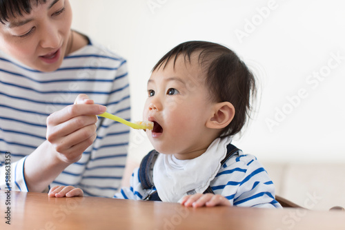 離乳食を母親に食べさせてもらう赤ちゃん photo