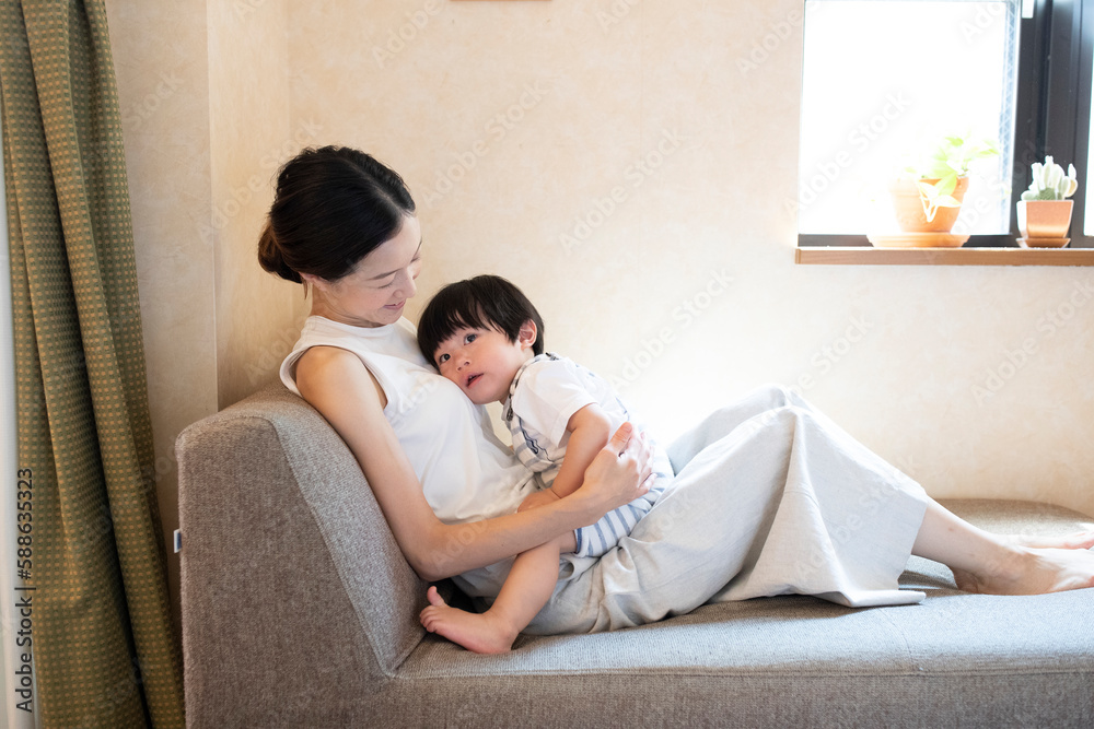 ソファーで子どもを抱く母親 ソファーで子どもを抱く母親