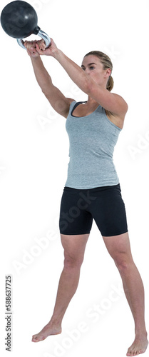 Serious muscular woman lifting kettlebell 