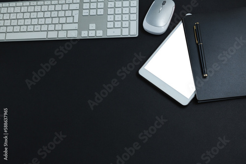 Keyboard, mouse, digital tablet, pen and organizer on black background