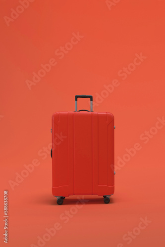 Red Suitcase on pink or magenta background. travel vacations concept.