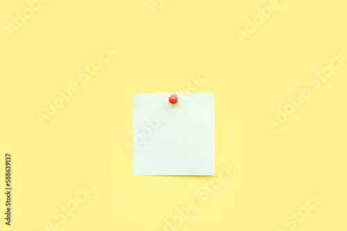 Pinned sticky note and pin on yellow background