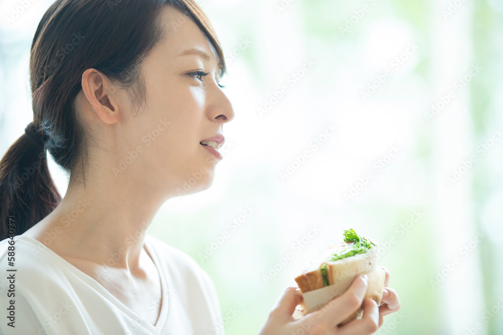 サンドイッチを食べる女性