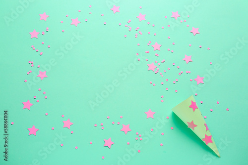Frame made of party cone with stars and confetti on green background