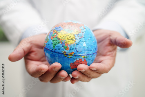 Asian man doctor holding globe, Elements of this image furnished by NASA.