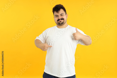 Concept of people, young fat man on yellow background