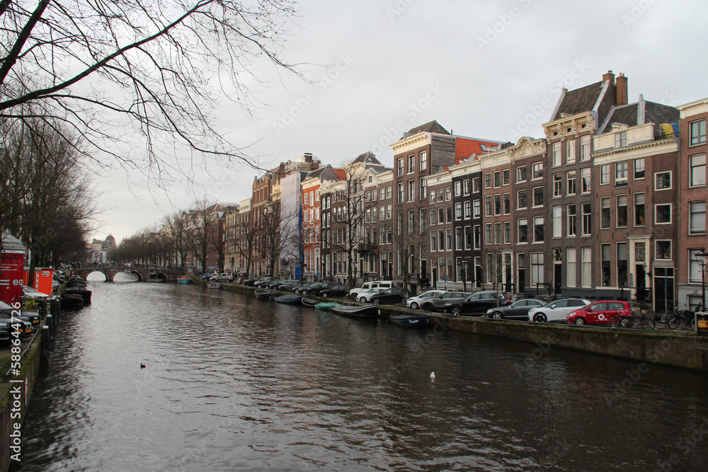 canal and old brick houses and flat buildings in amsterdam (the netherlands) 