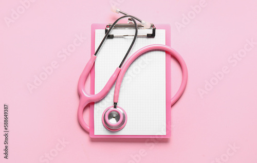 Stethoscope and clipboard on pink background