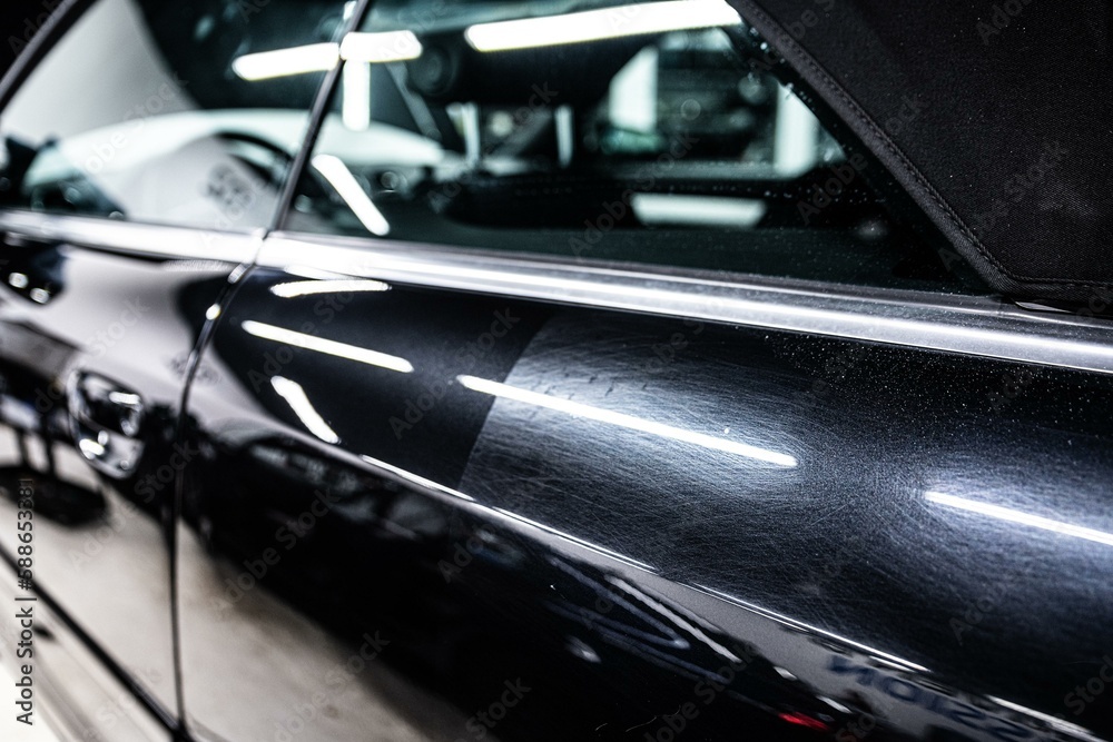 Before and after effect after polishing the paint and removing scratches on the paint of a black car