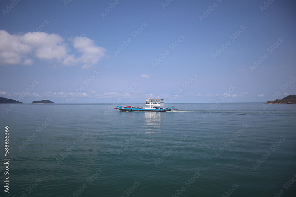 Front view in bright blue morning sky with clear white clouds and deep blue ocean in daytime gives calm and relaxing idea for cool background and copy space above the boat.