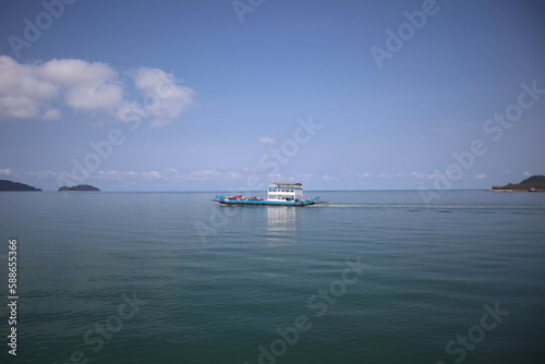 Front view in bright blue morning sky with clear white clouds and deep blue ocean in daytime gives calm and relaxing idea for cool background and copy space above the boat. © สุรศักดิ์ บุญยงค์