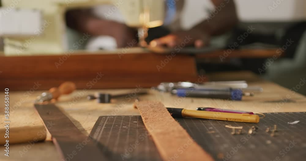 Hands of african american craftsman sewing leather in leather workshop Hands of african american craftsman sewing leather in leather workshop