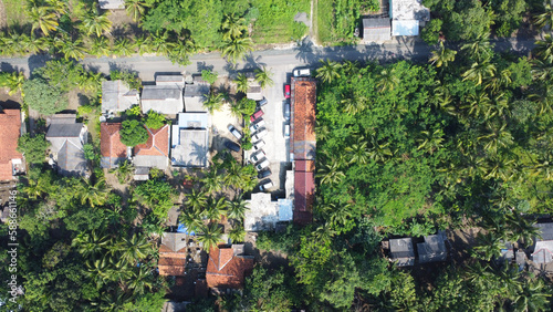Village houses with palm tree all around and parking lot, Pangandaran Indonesia photo
