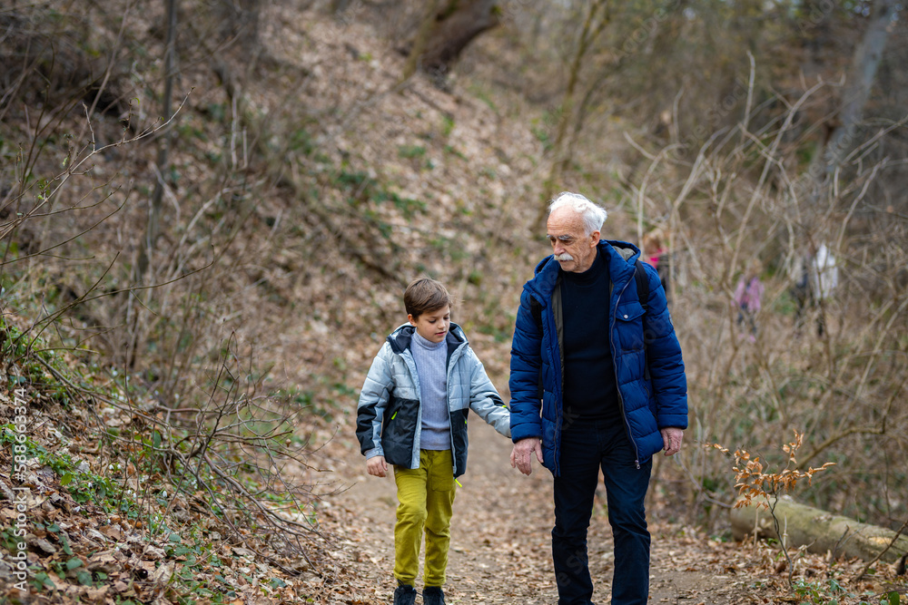 Grandfather and his grandson walking in the woods