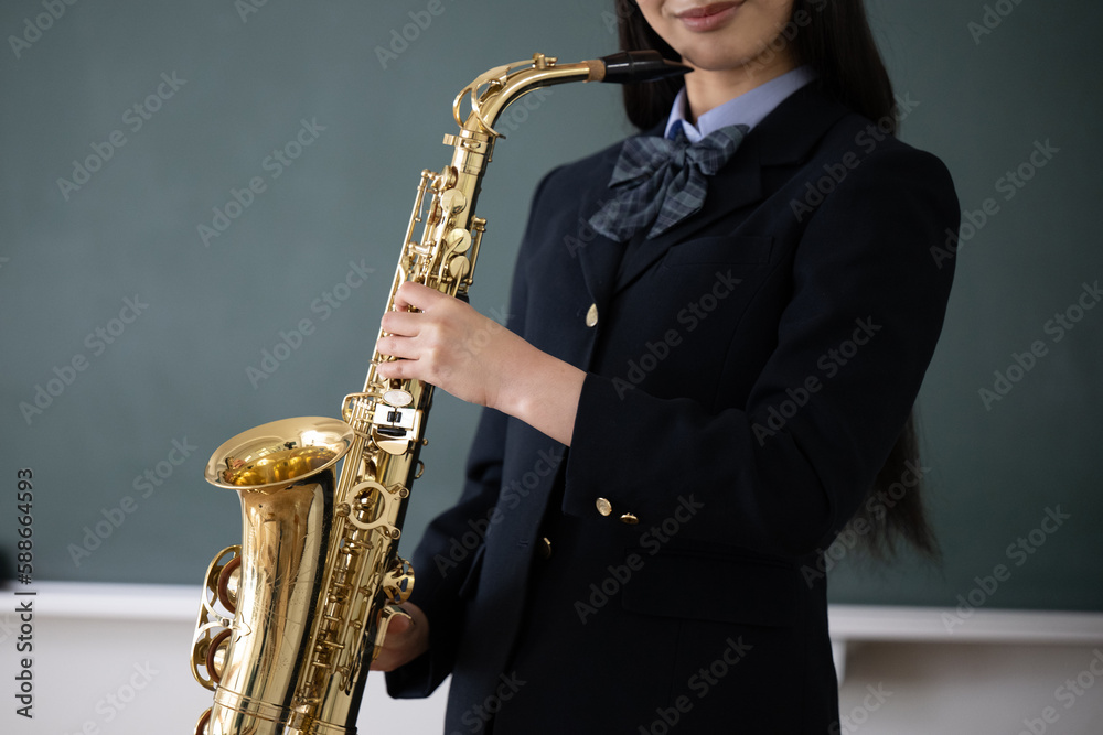 Fototapeta premium サックスをする学生 吹奏楽や部活のイメージ 顔無し