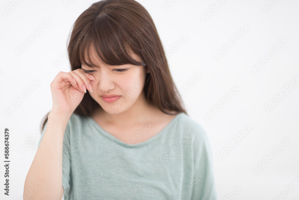目をこする女性