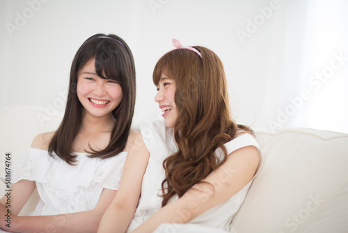 ソファーの上で笑う女性2人