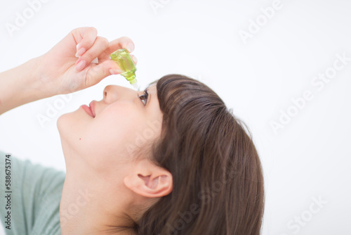 目薬を点している女性の横顔 photo