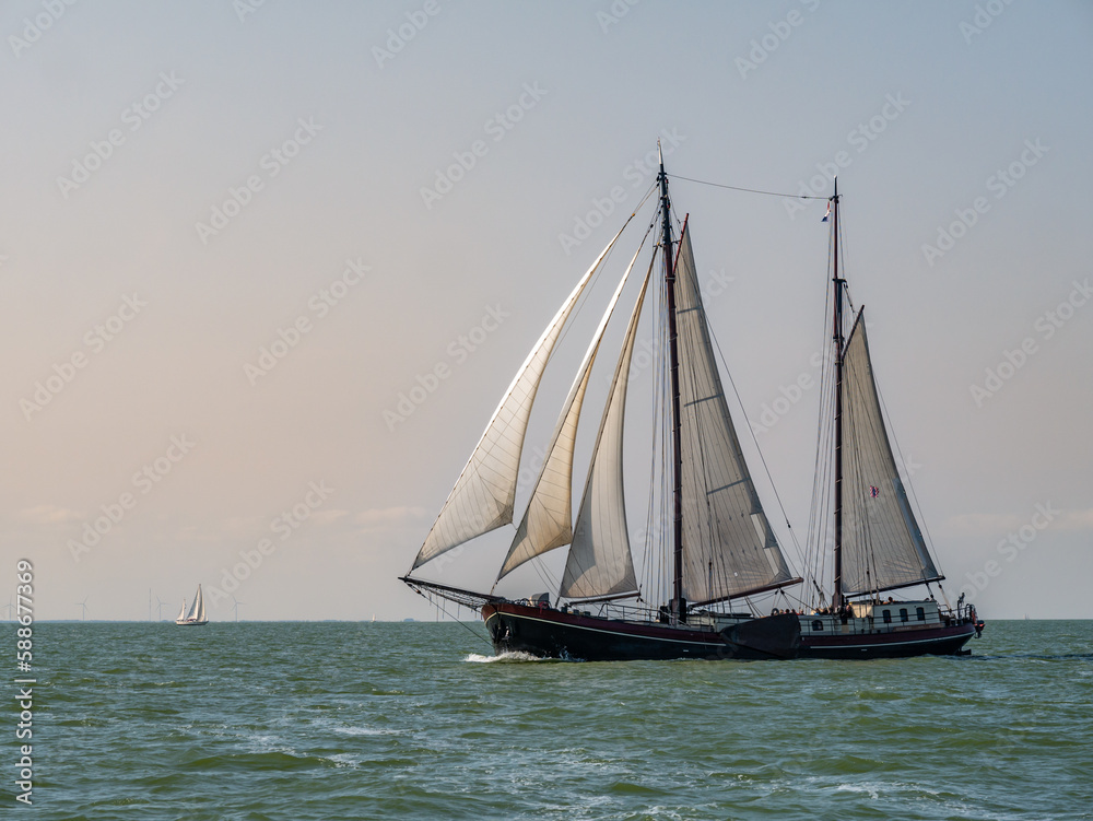 Traditional two-masted clipper sailing on IJsselmeer lake, Netherlands