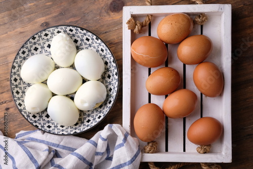chicken eggs on a white wooden cutting board. boiled eggs on ceramic plate. source of animal protein. telur rebus. 