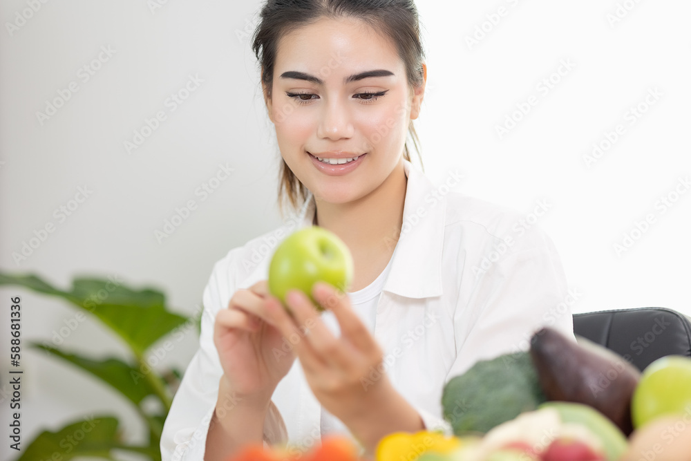 Happy professional nutrition healthful surrounded by a variety of fresh fruits and vegetables working on digital tablet and smiles. concept of right nutrition, diet and healthcare. Happy professional nutrition healthful surrounded by a variety of fresh fruits and vegetables working on digital tablet and smiles. concept of right nutrition, diet and healthcare.