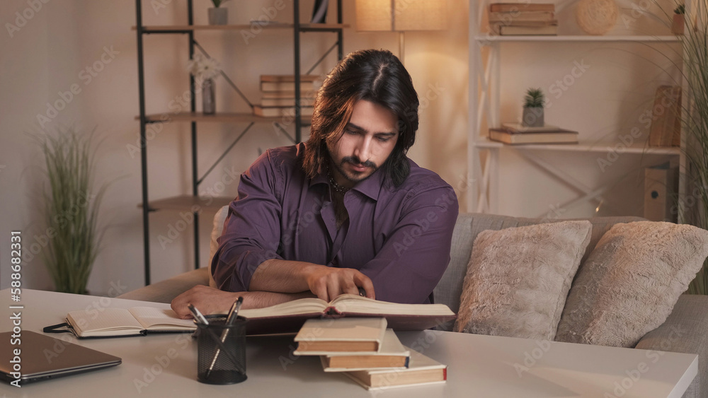 Book research. Home study. Knowledge education. Curious smart guy learning reading literature preparing for exam on couch at modern interior. Book research. Home study. Knowledge education. Curious smart guy learning reading literature preparing for exam on couch at modern interior.