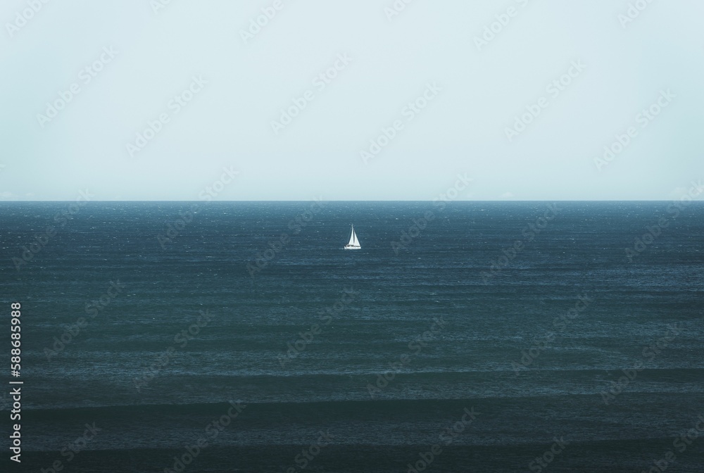View of a white boat sailing in the blue ocean before the horizon