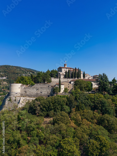 Vertical panoramic view from a drone of a hill (colle Cidneo) with park and historical castle in the Brescia town. Lombardy, Italy