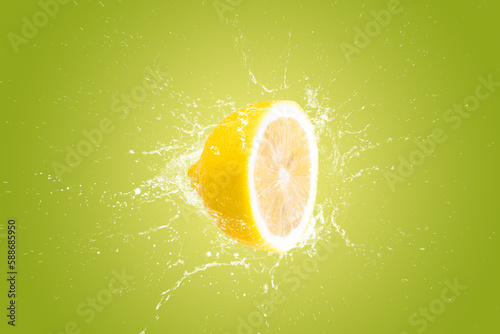 Creative layout made from Fresh Sliced lemon fruit and water Splashing on a green background.