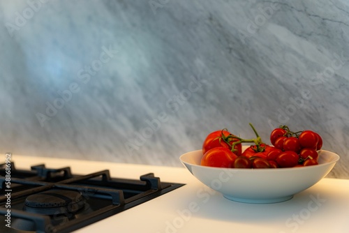Modern kitchen with tomato bowl by a black cooktop