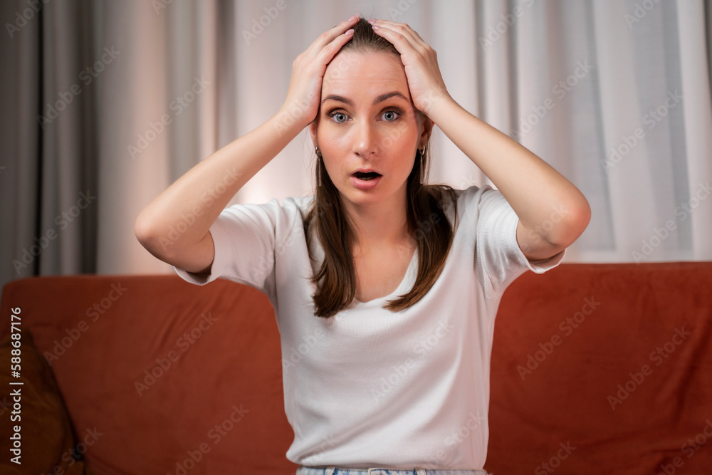 Frightened woman looks into the camera with bulging eyes and wide open mouth, being shocked by what she saw, looks with bated breath. Frightened woman looks into the camera with bulging eyes and wide open mouth, being shocked by what she saw, looks with bated breath.