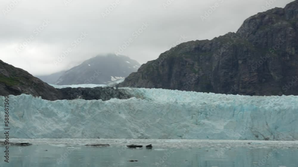 Beautiful view of a glacier from a lake and mountains under cloudy sky Beautiful view of a glacier from a lake and mountains under cloudy sky