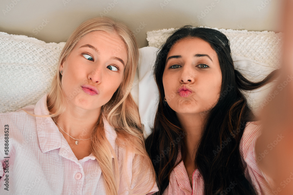 Funny, playful and portrait of women with a selfie for a memory, friendship or comic together. Goofy, silly and friends taking a photo in the bedroom during a sleepover being crazy and joyful Funny, playful and portrait of women with a selfie for a memory, friendship or comic together. Goofy, silly and friends taking a photo in the bedroom during a sleepover being crazy and joyful