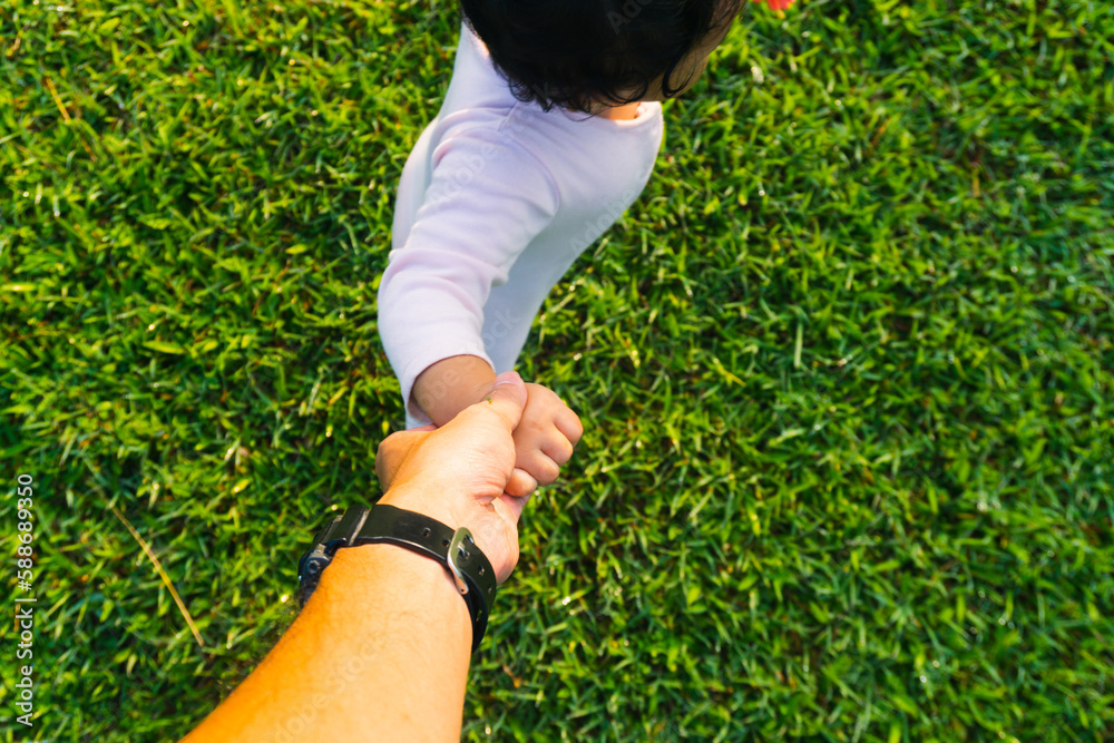 Unrecognizable father's hand lead his child son in summer forest nature outdoor, trust family concept Unrecognizable father's hand lead his child son in summer forest nature outdoor, trust family concept