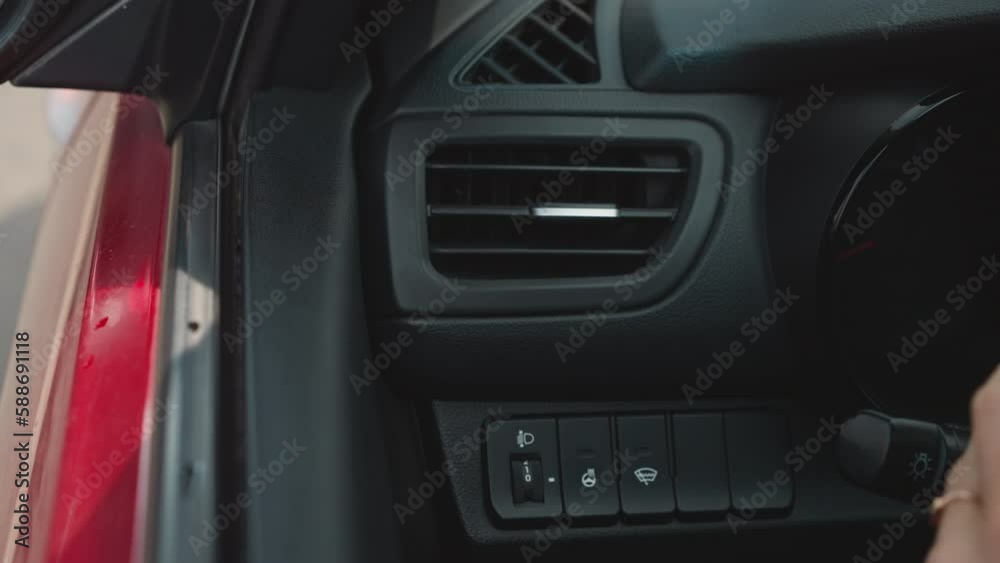 Hand of woman with red nails adjusting air conditioning to stabilize temperature in car. Female driver sits in vehicle turning on cooling system closeup Hand of woman with red nails adjusting air conditioning to stabilize temperature in car. Female driver sits in vehicle turning on cooling system closeup