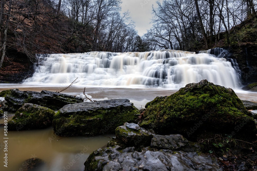 Obraz premium Long exposure shot of a cascade waterfall in the forest on a gloomy day