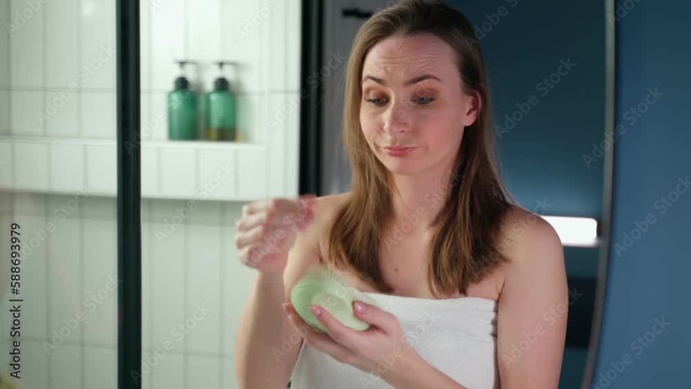 Healthy concept. A disgruntled woman shows a hair brush with long hair