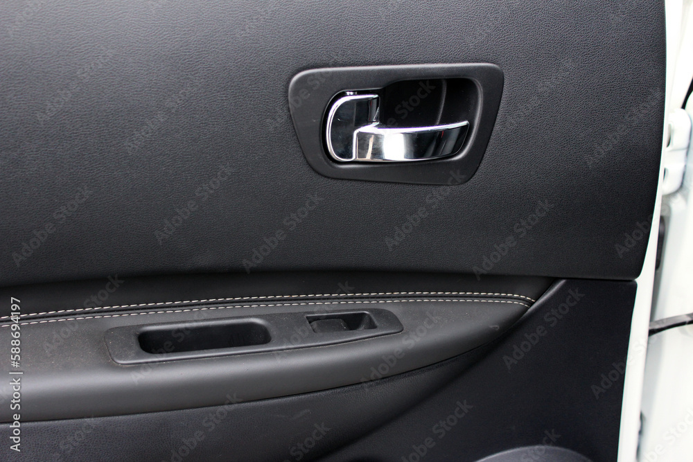 Car interior. Front door panel. Car door trim, door handle and control buttons. Car interior. Front door panel. Car door trim, door handle and control buttons.