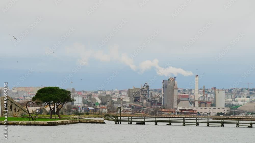 Beautiful view of flying birds above the reservoir in an industrial city