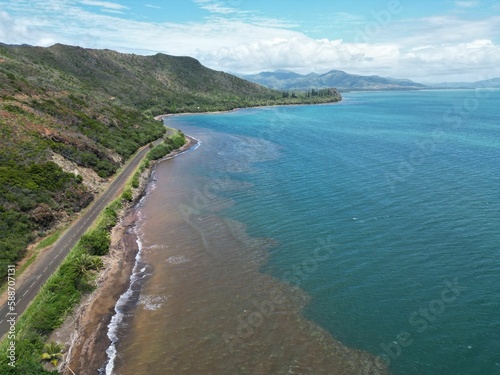 Beautiful shot of the blue ocean and the black beach in Houailou, New Caledonia photo